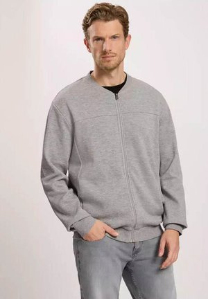 Szary rozpinany sweatshirt z okrągłym dekoltem, długimi rękawami i miękką teksturą. Posiada dwie boczne kieszenie i minimalne detale przeszycia.