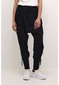 Pantalons noirs effilés à coupe décontractée, en tissu léger. Comprend des poches avant, une taille avec cordon de serrage et des poignets élastiques.