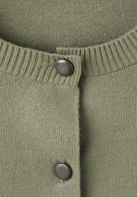 Cardigan verde lavorato a maglia con colletto a coste, fissato con un bottone scuro, che mette in mostra una consistenza morbida e punti uniformi.