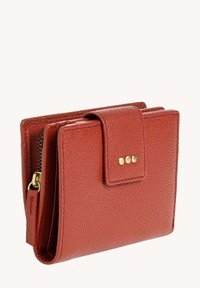 Portefeuille en cuir rouge avec une surface texturée, un compartiment zippé et une fermeture à pression ornée de trois rivets dorés.