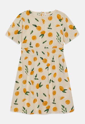 Robe en tissu léger avec un fond crème, ornée de tranches d'orange et de feuilles vertes. Manches courtes et taille élastique.