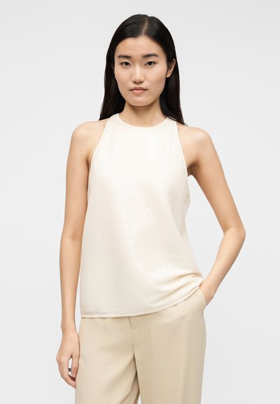 Šviesiai smėlio spalvos be rankovių palaidinė, su lygiu, šiek tiek blizgančiu paviršiumi, aukštu kaklu ir laisvu siluetu. Minimalistinis dizainas be raštų.