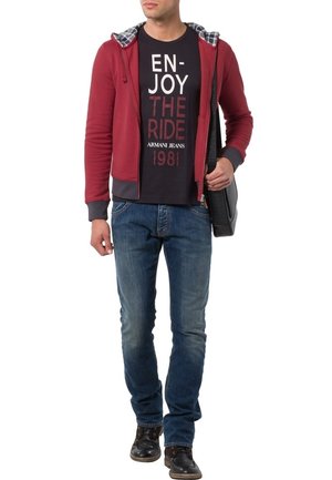 Haut à zip maroon avec des accents gris sur un t-shirt graphique bleu marine. Porté avec un jean bleu et des chaussures noires, portant un sac messager noir.