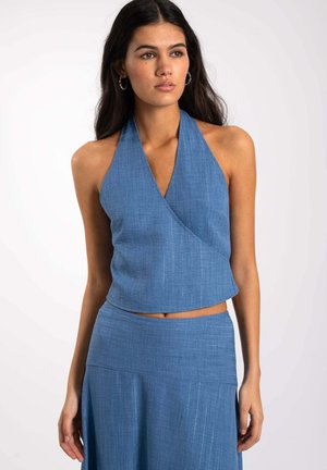 Top halter azul con tejido texturizado, diseño envolvente y longitud corta. Presenta un escote en forma de V y material suave y ligero.