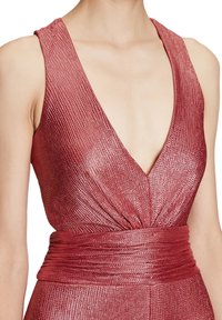 Djup V-ringad ärmlös klänning i metallisk rosabads tyg, med en texturerad yta och en samlad midja med ett brett midjeband.