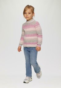 Pull en tricot avec des rayures roses, grises et blanches ; col montant ; associé à un jean bleu ; portant des baskets grises et blanches. Enfant marchant vers l'avant.