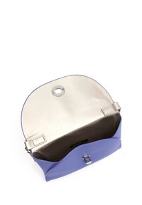 Sac en cuir violet avec un rabat arrondi et une quincaillerie en argent. Présente un extérieur lisse et un intérieur doublé de satin avec une fermeture magnétique.