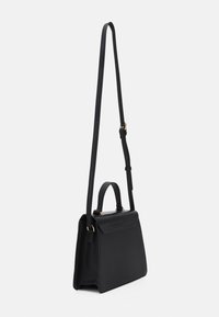 Sac à main noir structuré en cuir lisse avec un rabat en cuir embossé crocodile, équipé d'une poignée courte et d'une bandoulière longue et réglable.