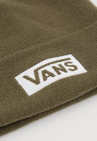 Bonnet en maille vert olive avec un patch logo Vans rectangulaire blanc cousu sur le bord replié.