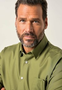 Groene overhemddas met een zak, gekenmerkt door een gladde textuur en een klassiek kraagontwerp, gecombineerd met zilveren knopen en een gelijkmatige pasvorm.