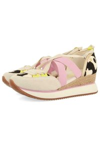 Scarpe con zeppa con tomaia in camoscio crema e stampa bovina nera, dotate di cinturini in elastico rosa e con una suola intermedia in juta intrecciata. Suola in gomma testurizzata.
