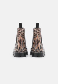 Botines negros con panel de estampado de leopardo, paneles laterales elásticos y suela de goma texturizada. Diseño estilizado con tiradores en la parte trasera.