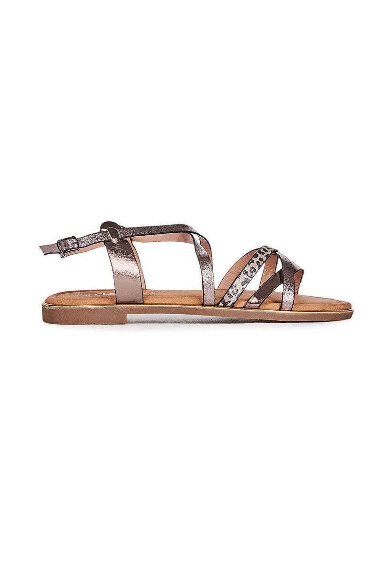 Metallic bronze flade sandaler med krydsede stropper, en ankelspænde og et leopardmønstret accent. Glat tekstur og åben tå-design.