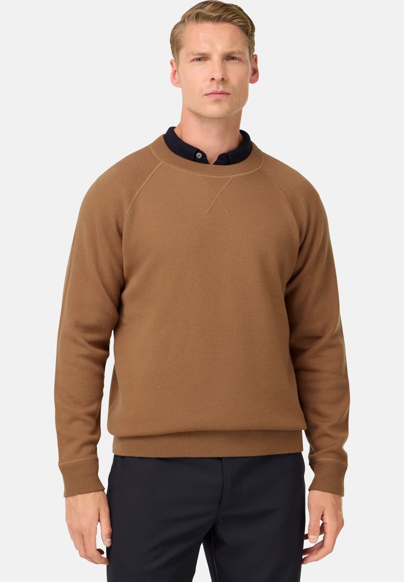 Ruda sportinė palaidinė su ilgomis rankovėmis, apykakle ir dygsniuotais mansetais bei apdarais. Minkšta medžiaga su šiek tiek tekstūruota paviršiumi. Po ja matyti tamsiai mėlyna palaidinė su apykakle.