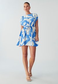 Kleita ar zilu un baltu abstraktu rakstu, īsām puff piedurknēm, elastīgu jostu un paplatinātu svārku. Audumam ir viegls textures.