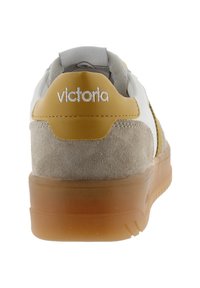 Sneaker con un design in materiali misti, caratterizzato da pelle bianca, suede beige e un accento giallo sul tallone. Suola in gomma trasparente.