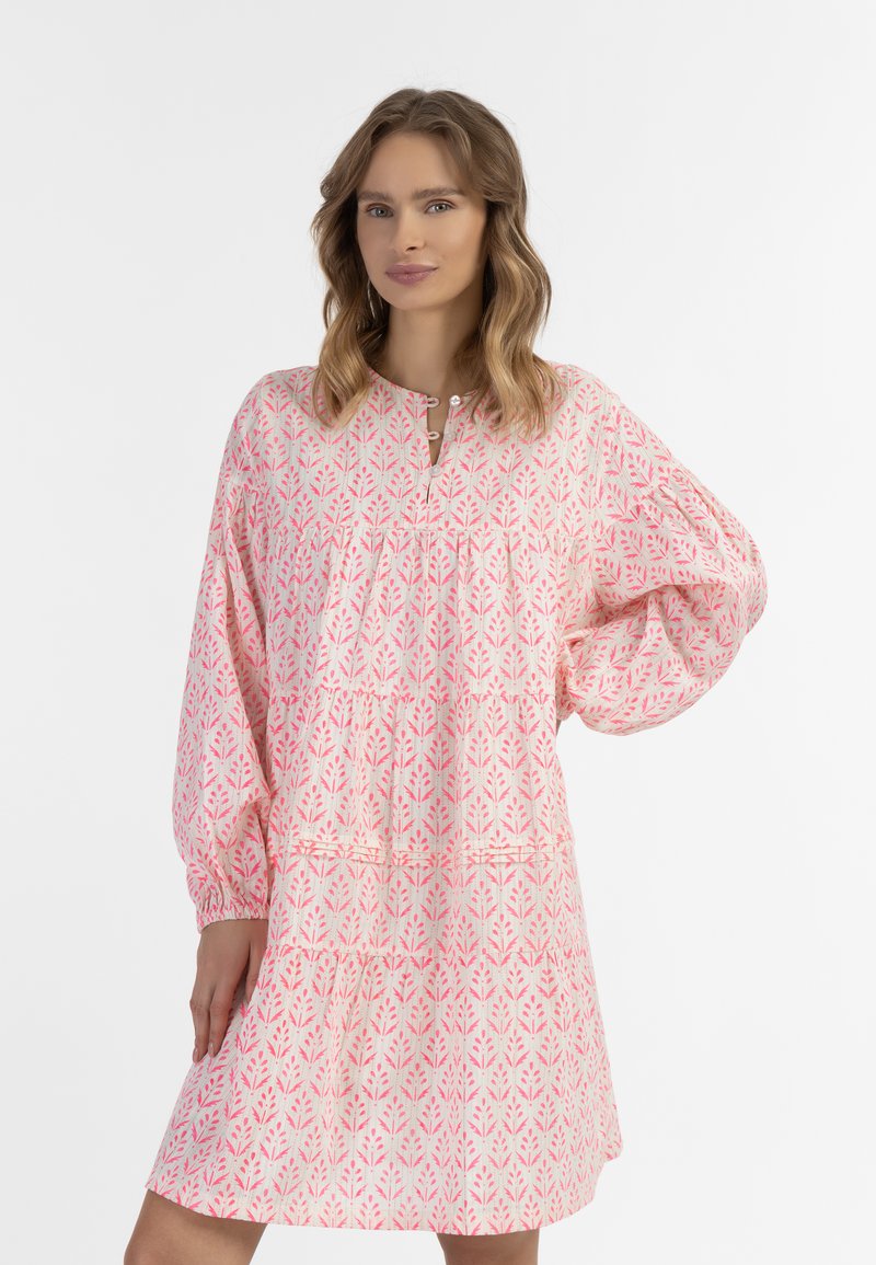 Ružové šaty s dlhým rukávom a kvetinovým vzorom, s gather pásom a výstrihom do V. Vyrobené z ľahkého materiálu, s volánovými rukávmi.