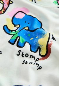 Colorful cotton fabric featuring playful cartoon elephants in blue and pink with a watercolor effect, accompanied by the text "Stomp stomp."
