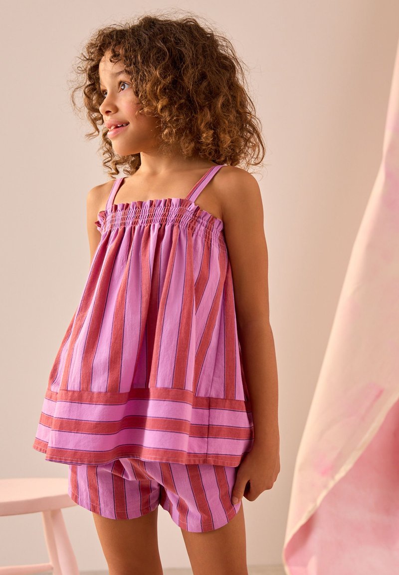 Striped purple and pink sleeveless top with smocked bodice, paired with matching shorts. Light fabric, loose fit, and playful design.