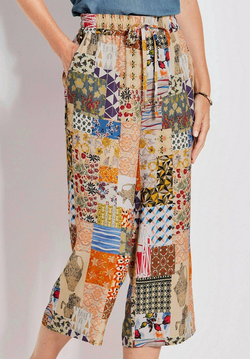 Multicolore patchworkbroek met verschillende bloem- en geometrische patronen, een elastische tailleband en zijzakken. Losse pasvorm en cropped lengte.