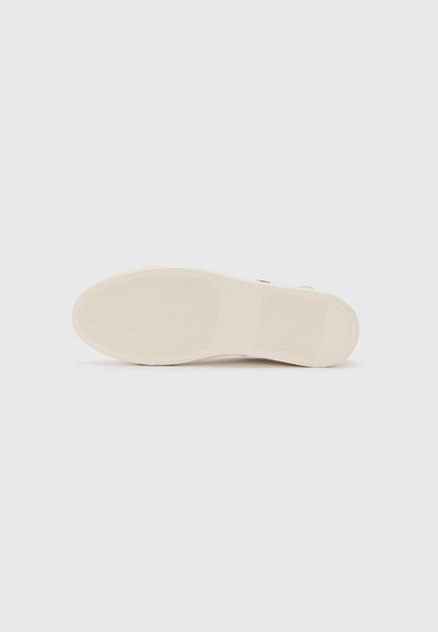 White sneaker sole with textured grip patterns on heel and ball areas, shown against a plain white background.