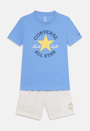 Camiseta de algodón azul con un gráfico de estrella amarilla, texto "Converse", y pantalones cortos grises con bordado del logo en el dobladillo.