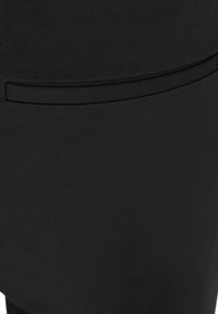 Svart tyg med en matt yta har en elegant, minimalistisk design, och en horisontell fickdetalj är synlig högst upp.