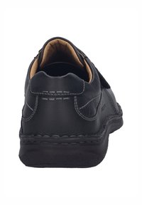 Zapato de cuero negro con parte trasera redondeada, detalles de costura, un suave forro interior y una suela negra resistente para mayor comodidad y soporte.