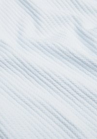 Világoskék textúrájú szövet, bordás mintázattal, amely finom hullámokat és mélységet teremt a felületen. Puha, szőtt anyag.