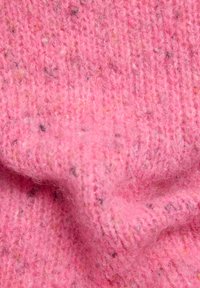 Weicher, rosafarbener Strickstoff mit strukturierter Oberfläche und dezenten Sprenkeln in verschiedenen Farben. Das Material wirkt flauschig und warm.