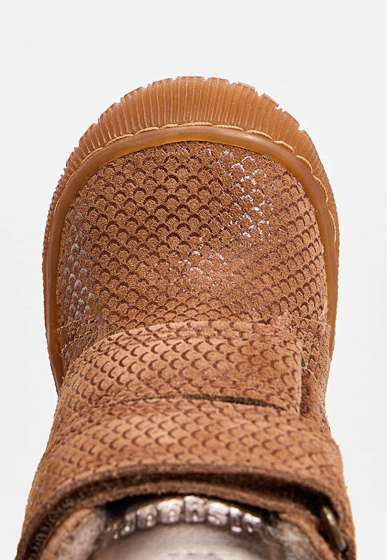 Braune Wildlederstiefel mit strukturiertem Reptilmuster-Obermaterial, verstellbarem Riemen und robustem Gummisohle. Merkmale sind eine runde Zehenpartie und geriffelte Kanten.