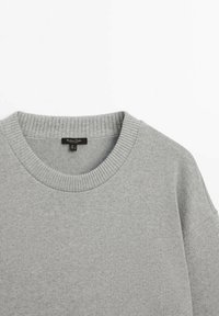 Pull tricot gris clair à col rond avec col côtelé et étiquette Massimo Dutti à l'intérieur du col.