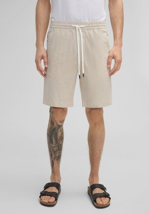Beige gestreepte zwembroek met een elastische tailleband en een witte trekkoord. Beschikt over twee zijzakken, een gestructureerde stof en een rechte snit.