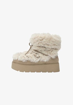 Beige faux fur ankelstøvle med en tyk platformssål, rund tå og snøredetaljer foran. Blød tekstur hele vejen igennem.