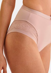 Culottes taille haute rose clair avec une texture lisse et un détail en dentelle présentant des motifs floraux le long de la ceinture.