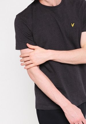 Dunkelgraues Baumwoll-T-Shirt mit rundem Ausschnitt und kurzen Ärmeln. Mit kleinem gelbem Logo auf der Brust. Weiche Textur.