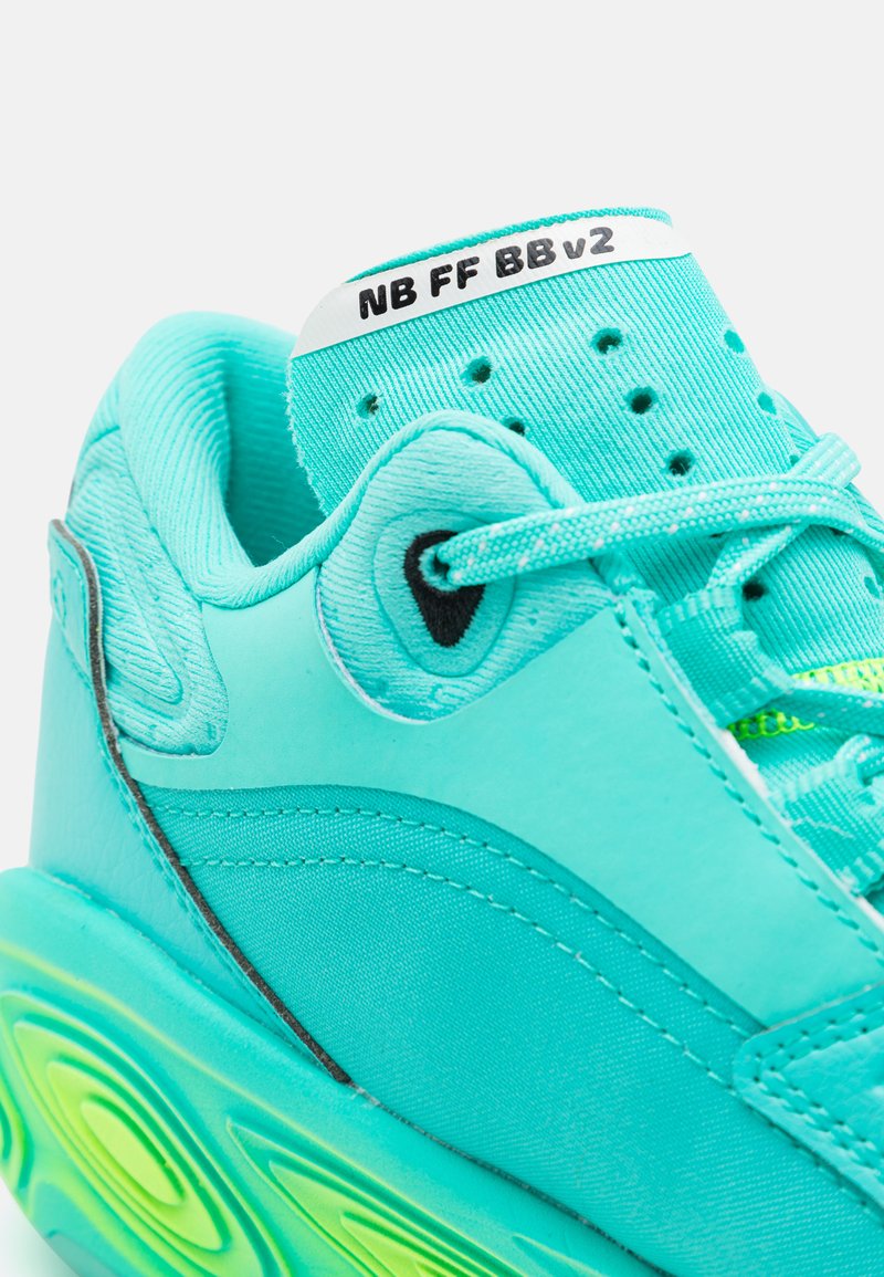 Nahaufnahme eines türkisfarbenen Sneakers mit gemustertem Sohlen, gestrickter Zunge mit dem Aufdruck "NB FF BB v2" und passenden Schnürsenkeln.