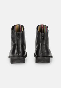 Stivali in pelle nera alla caviglia con zip posteriore, finitura texturizzata e fodera interna a strisce multicolori. Design con tacco a blocco spesso.