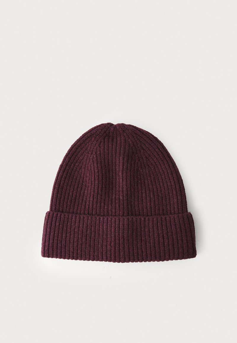 Kastanjefärgad stickad beanie med ribbstruktur och vikt kant. Det mjuka materialet ger värme och komfort. Enkel och avskalad design.