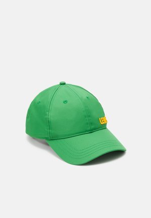 Casquette de baseball verte avec texte brodé jaune à l'avant, coutures visibles et trous de ventilation sur les panneaux supérieurs.