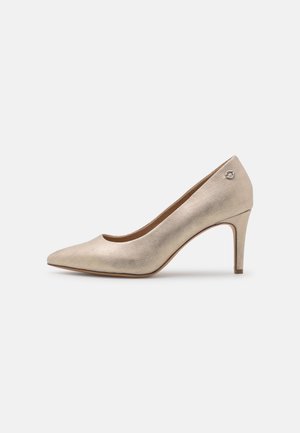 Zapato de tacón alto beige con un acabado metálico texturizado, punta afilada y un tacón delgado. Presenta un pequeño acento de logotipo en el costado.