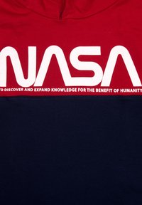 T-shirt in cotone rosso e blu navy con grande scritta bianca "NASA" e una dichiarazione di missione sottostante. Design semplice con maniche corte.