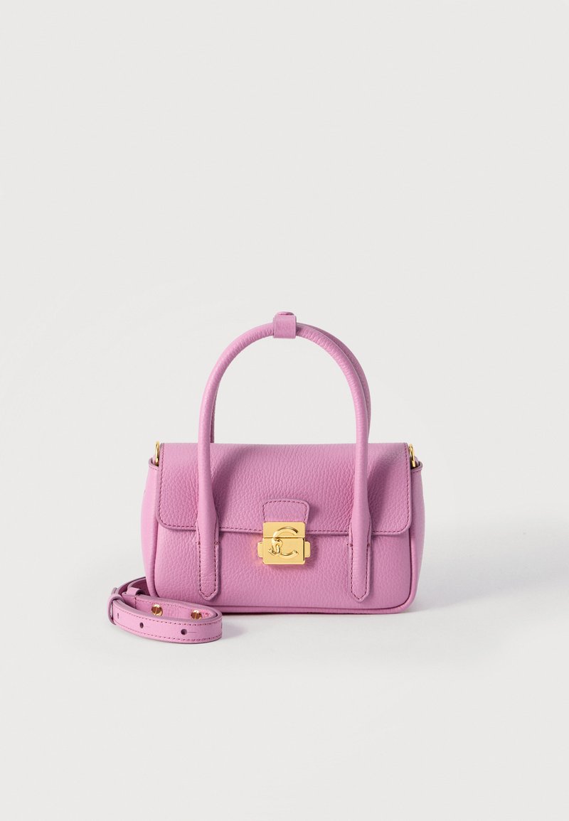 Μικρή ροζ δερμάτινη τσάντα χειρός με στρογγυλεμένες χειρολαβές, χρυσό κούμπωμα και αποσπώμενο λουράκι ώμου σε λευκό φόντο.