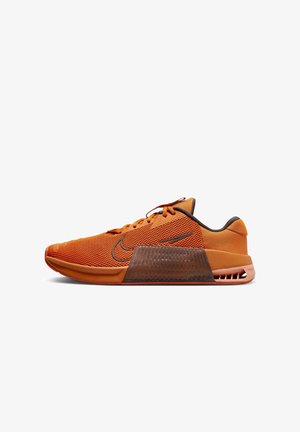 Baskets de sport orange et marron avec tige en mesh, logo Nike, semelle intermédiaire épaisse et détail visible de l'amorti au talon, vues de côté.