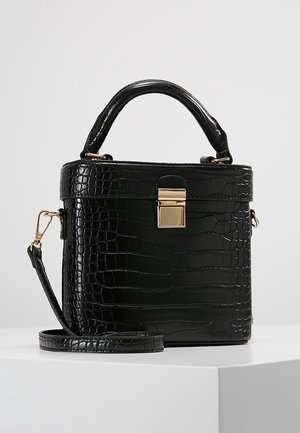 Schwarze Handtasche aus krokodilgeprägtem Leder mit Henkel oben, goldfarbenem Verschluss und abnehmbarem Schulterriemen auf weißem Untergrund.