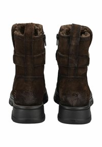 Botas de tobillo de ante marrón con forro de piel sintética, doble correa ajustable y suela de goma negra texturizada. Cierre de cremallera en el costado.