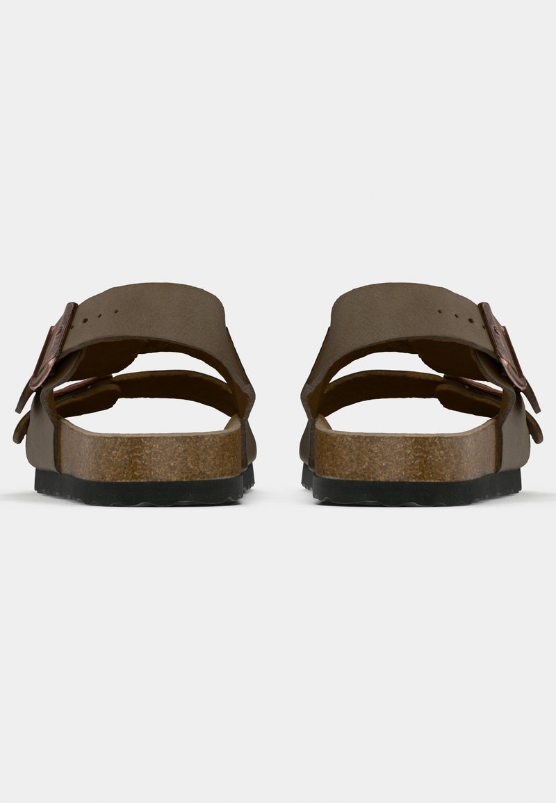 Sandales marron avec deux larges sangles, boucles, et une semelle en liège rembourrée. Semelle en caoutchouc noir et design à bout ouvert visible de l'arrière.