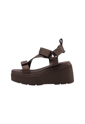 Sandalo con platform marrone con cinturini regolabili, chiusure in velcro e una linguetta su suola spessa, mostrato di lato.