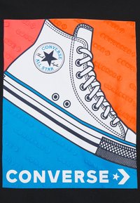 Ilustrace tenisky Converse Chuck Taylor s bílou plátěnou vrchní částí, černými tkaničkami, modrým pruhem a kulatým logem na barevném pozadí.