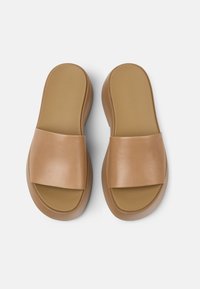 Sandales en synthétique marron avec une large bande avant et une semelle intérieure texturée. Semelle légèrement contournée pour le confort, design minimaliste.